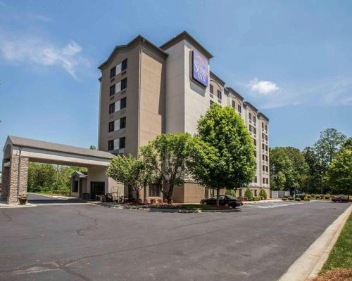 a large building with a parking lot in front of it at Sleep Inn Greensboro Airport in Greensboro