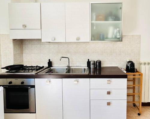 a kitchen with white cabinets and a sink at Appartamento con Vista Panoramica e Garage Ideale per Famiglie 4 Persone in Fiuggi