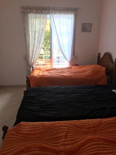 two beds in a bedroom with a window at Casa do Mar - Praia de Manta Rota in Vila Nova de Cacela
