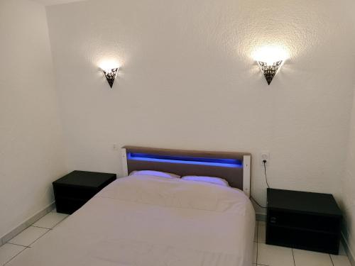 - une chambre avec un lit et deux lumières sur le mur dans l'établissement Appartement cosy avec patio en RDC, à Perpignan