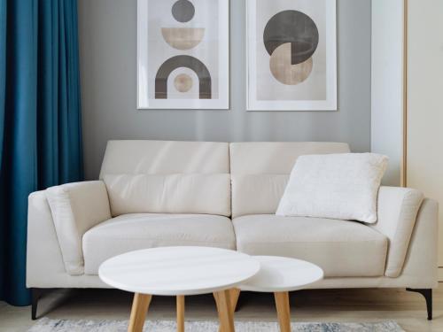 a living room with a white couch and a table at Parkside Haven in M. Ciurel