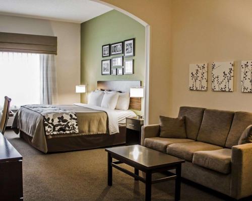 a hotel room with a bed and a couch at Sleep Inn & Suites Harrisburg - Hershey Southwest in Harrisburg