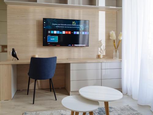 a room with a desk with a tv on a wall at Parkside Haven in M. Ciurel