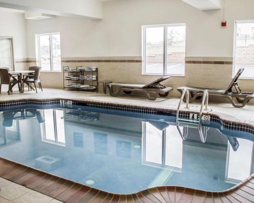 a swimming pool with chairs and a table at Sleep Inn & Suites Harrisburg - Hershey Southwest in Harrisburg