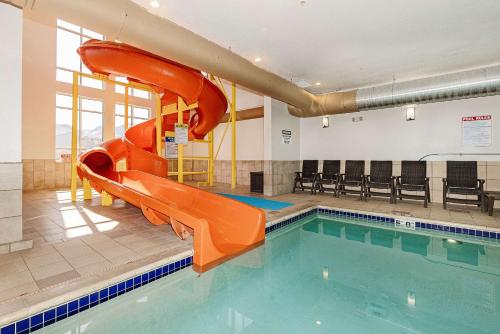 an indoor swimming pool with a slide in a building at Comfort Inn & Suites Logan Near University in Logan