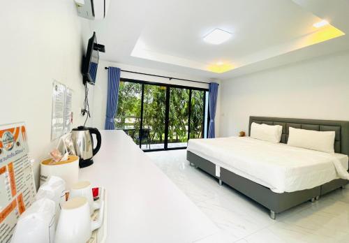 una camera da letto con due letti e una grande finestra di I AM Cottage เฮือนแก้วมณี a Nakhon Pathom
