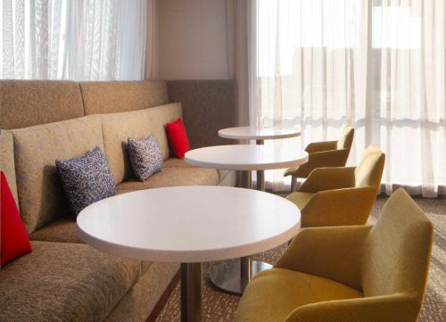 a living room with a couch and tables and chairs at Hampton Inn Ogallala in Ogallala