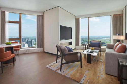 a living room with a couch and a tv at Hyatt Regency Changshu Kuncheng Lake in Changshu