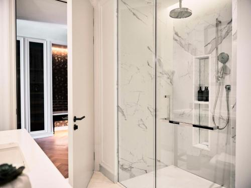 a bathroom with a shower with marble walls at Park Hyatt London River Thames in London