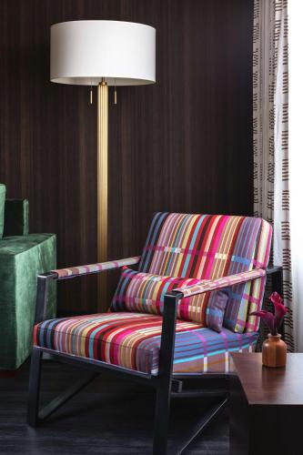 a colorful chair in a living room with a lamp at Graduate by Hilton Columbus in Columbus