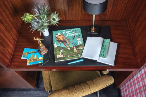 a table with two books and a lamp on it at Graduate by Hilton Columbus in Columbus