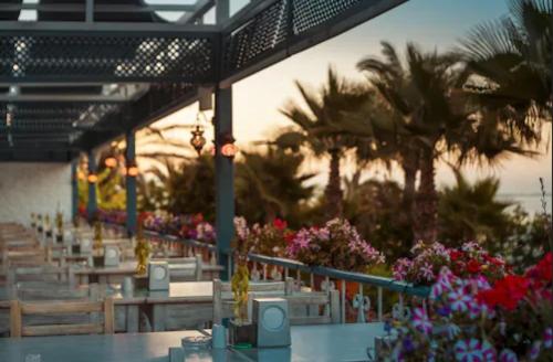 a restaurant with tables and flowers and palm trees at Hotel Turan Prince - All Inclusive in Side
