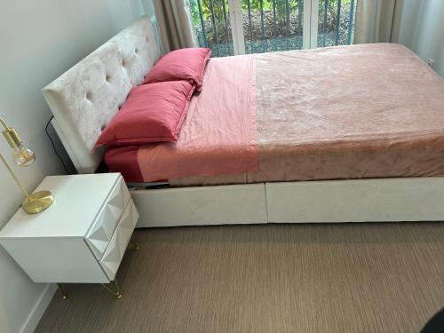 - une chambre avec un lit avec des draps roses et une fenêtre dans l'établissement Home in Paris, à Bezons