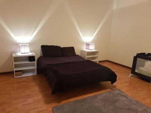 ein Schlafzimmer mit einem Bett und zwei Nachttischen in der Unterkunft Madeira house garden Villa in Estreito de Câmara de Lobos