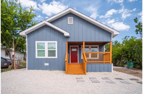 a small blue house with a red door at Comfortable 4BR2.5BA Family Home Near Riverwalk in San Antonio