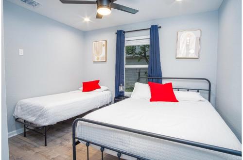 two beds in a room with blue walls and red pillows at Comfortable 4BR2.5BA Family Home Near Riverwalk in San Antonio