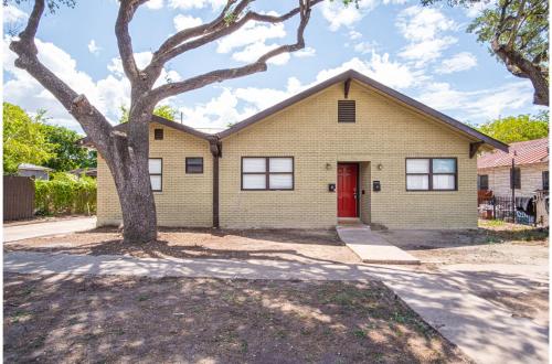 a yellow house with a red door and a tree at Modern Living 3BR2BA Close to Amazing Downtown in San Antonio