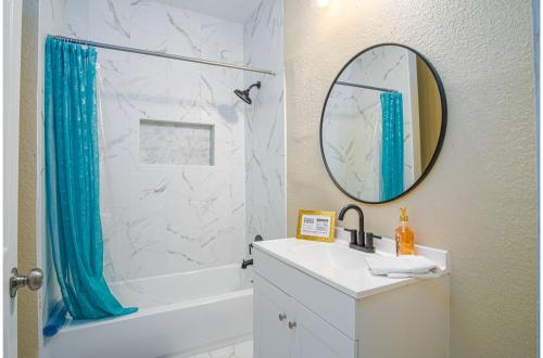 a bathroom with a tub and a sink and a mirror at Modern Living 3BR2BA Close to Amazing Downtown in San Antonio