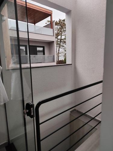 a glass door leading to a balcony with a window at Suíte família 14 in Pontal do Paraná