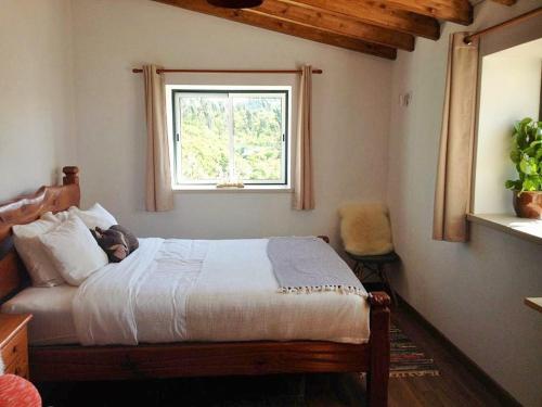 a bedroom with a bed and a window at Quinta Vida Verde in Alvaiázere