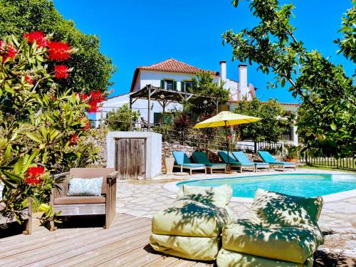 a backyard with a pool with chairs and a house at Quinta Vida Verde in Alvaiázere