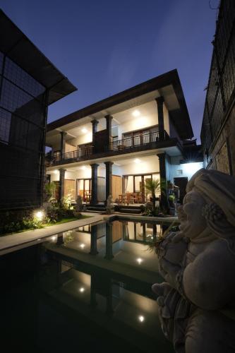 a villa with a swimming pool at night at Winaka Ubud in Ubud