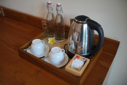 a tray with a tea kettle and cups on a table at Winaka Ubud in Ubud