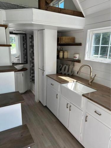 a kitchen with white cabinets and a sink at Na Akron Homes in Owerri
