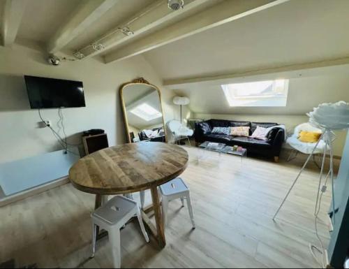 una sala de estar con una mesa y un sofá en Charmant duplex centre historique Abbaye aux hommes, en Caen
