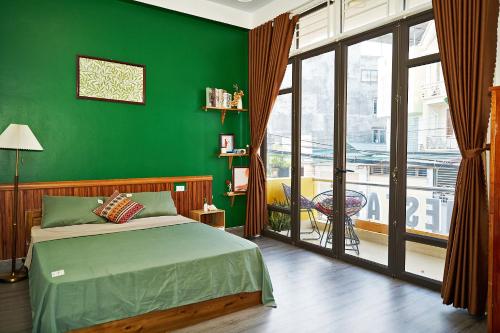 a green bedroom with a bed and a large window at Sen's Homestay - Motorbike Rental - Cao Bang City in Cao Bằng