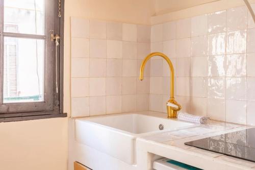 La salle de bains est pourvue d'une baignoire blanche avec un robinet d'or. dans l'établissement Halte Poétique au Panier 2 chambres Balcon & Clim, à Marseille