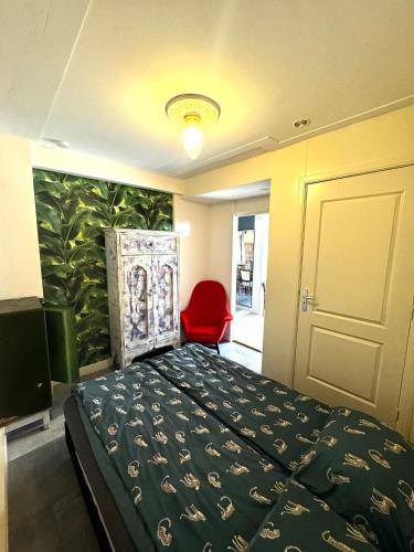 a bedroom with a bed and a red chair at Friend zone in Zaandam