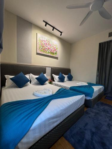 two beds in a hotel room with blue pillows at KL Sentral Dua Sentral Cozy Homestay Apartments by Hollywood Homes #FreeCarPark in Kuala Lumpur