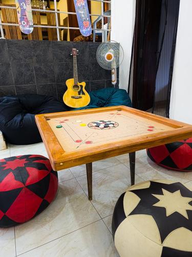 a wooden table with a guitar on top of it at Evoke Hostels, Hiriketiya beach in Dickwella