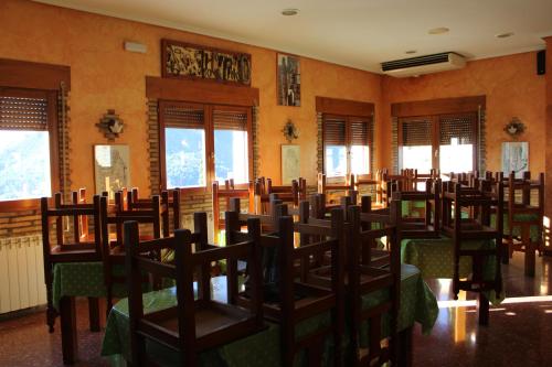 a room with a bunch of chairs and tables at Pension Los Mallos in Riglos