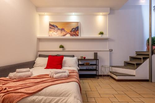 ミラノにあるRomantic Suite Navigli - 15min Duomo - FREE parkingの赤い枕が付いたベッドが備わる客室です。