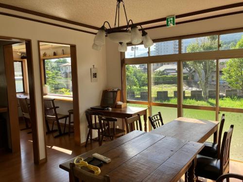 Itoshima民宿いとぐるま的一间有桌子、椅子和窗户的餐厅