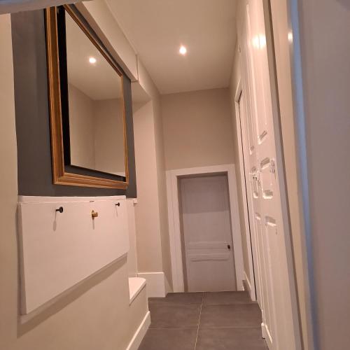 un couloir avec une porte avec un miroir et une porte dans l'établissement La chambre des notaires, à Moulins