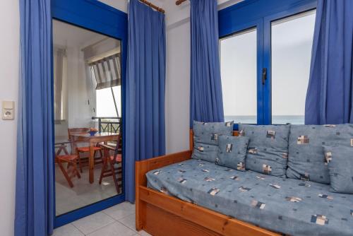 a bedroom with a bed with blue drapes at Finikas Studios & Apartments - Kalamaki Holidays in Kalamaki