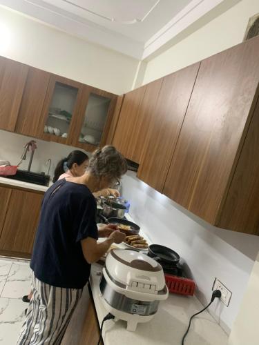 a woman standing in a kitchen preparing food at Mai chau Horizon Homestay in Mai Chau