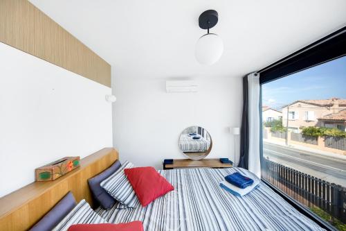 Cette chambre dispose d'un balcon avec une grande fenêtre. dans l'établissement Exceptionnel Vue 360 Degrés Roof Top Vue Mer Clim Wifi Parking By HC, à Hyères