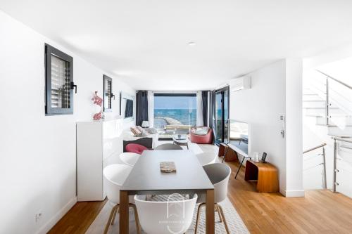 un salon blanc avec une table et des chaises dans l'établissement Exceptionnel Vue 360 Degrés Roof Top Vue Mer Clim Wifi Parking By HC, à Hyères
