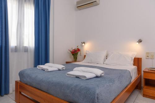 a bedroom with a bed with two towels on it at Finikas Studios & Apartments - Kalamaki Holidays in Kalamaki