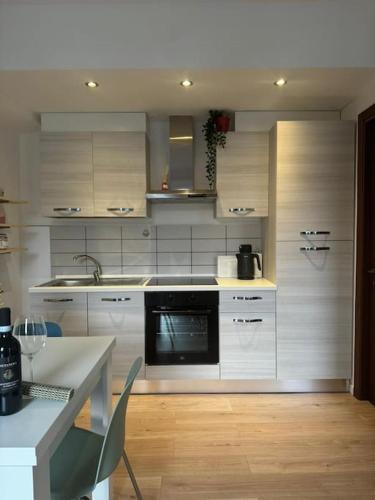 a kitchen with white cabinets and a black microwave at In center Cà del Pescatore lake view in Lierna