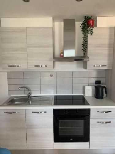 a kitchen with a sink and a stove top oven at In center Cà del Pescatore lake view in Lierna
