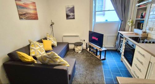 a living room with a couch and a tv at Little Dockray One-Bed Apartment Centre of Penrith in Penrith