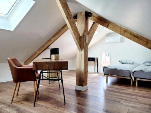 - une chambre avec un bureau, un lit, un lit et une table dans l'établissement Maison bord de mer, à Varaville