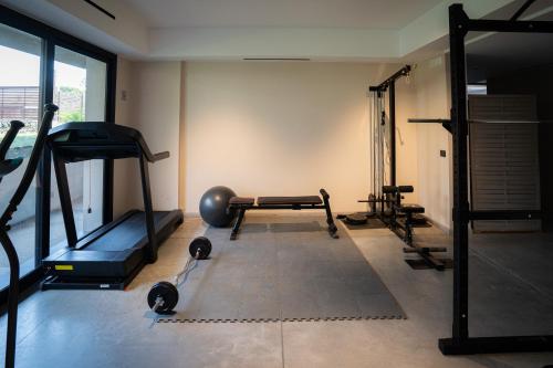 a gym with several tread machines in a room at Ollen apartments in Catania