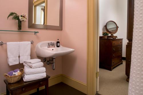 a bathroom with a sink and a mirror and towels at Rachael's Dowry Bed and Breakfast in Baltimore