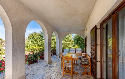 an outdoor patio with a wooden table and chairs at Apartman ALEN in Klanice Dobrinj